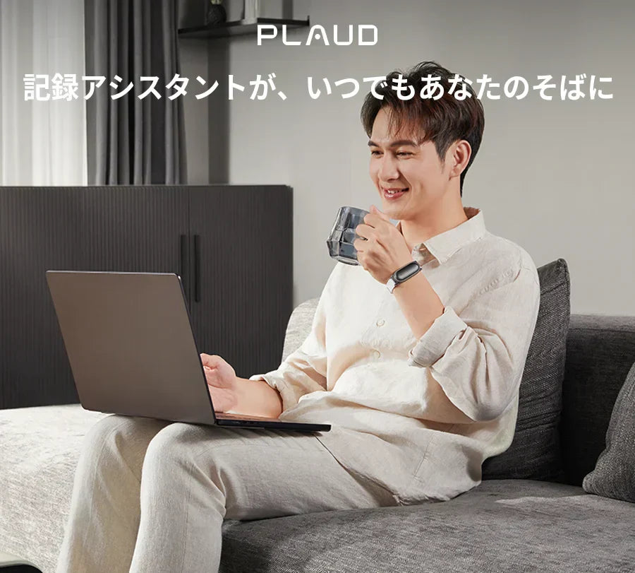 リストバンドでPlaud NotePinを着用し、PC作業をする男性。